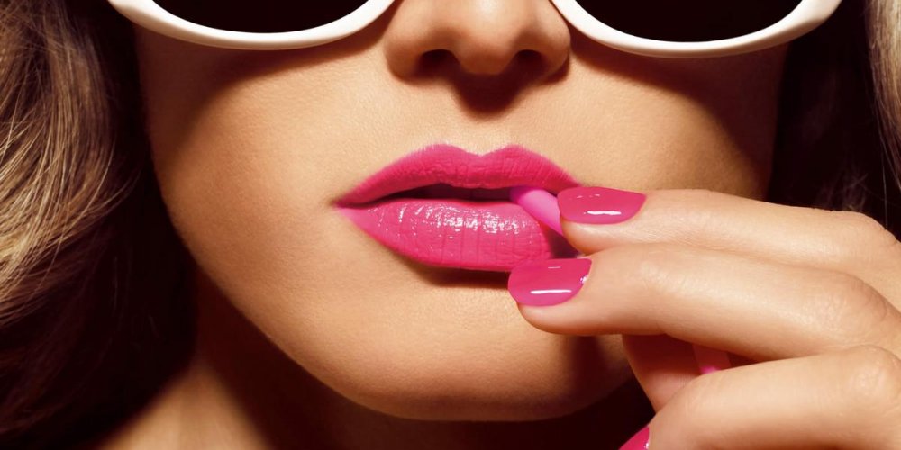 Взрослая женщина с губами, наносит помаду, крупным планом лица.