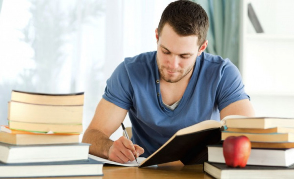 Мужчина читает и пишет ручкой - взрослый мужчина занимается чтением и письмом.