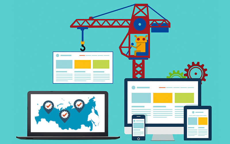 Строительный кран на фоне электроники: мобильный телефон, компьютерный монитор.
