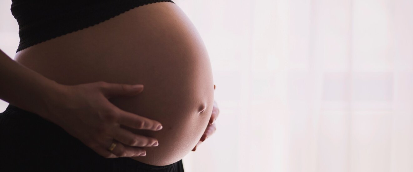 Человек держит руку на животе, показывая боль в желудке.