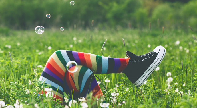 Фотография портрета человека сидящего на траве в поле с бейсбольным мячом.