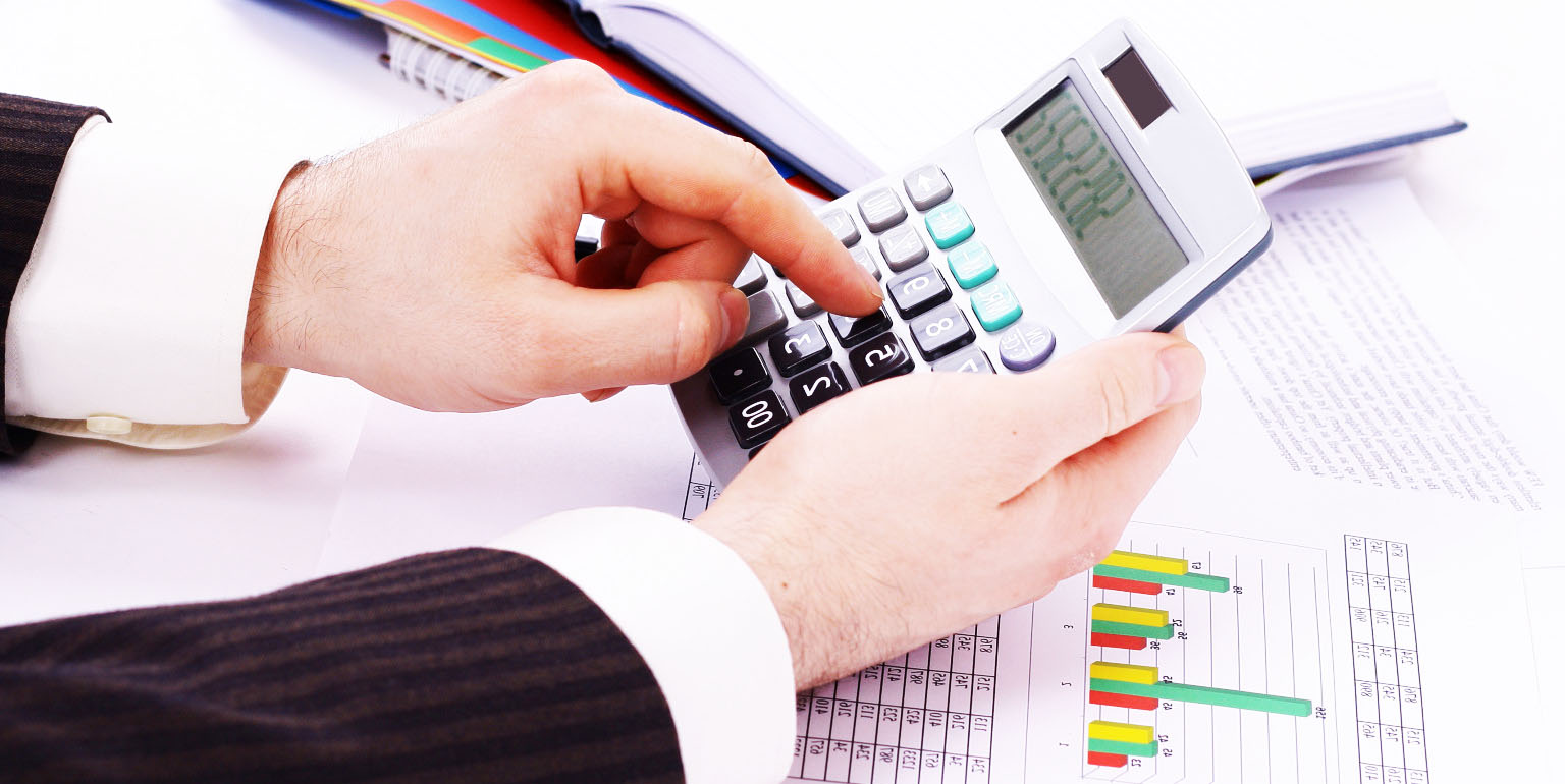 Человек в черной кофте и джинсах, стоящий на городской улице.