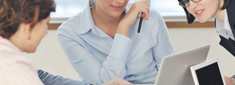 Человек в синей рубашке, работающий за ноутбуком и компьютером. Техника и одежда.