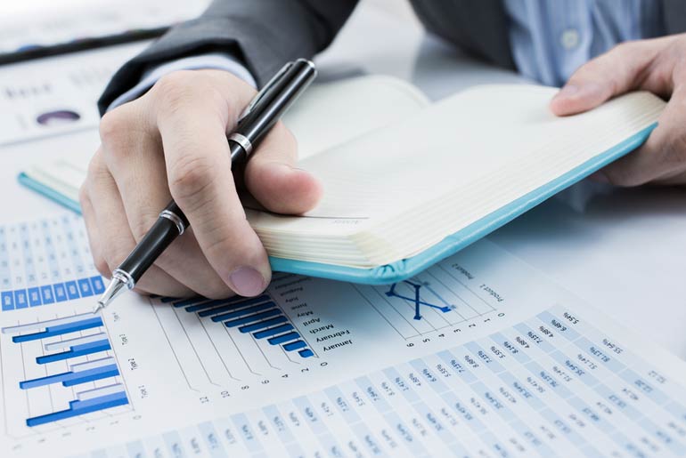 Человек использует отвертку для ремонта устройства, рядом лежит ручка.