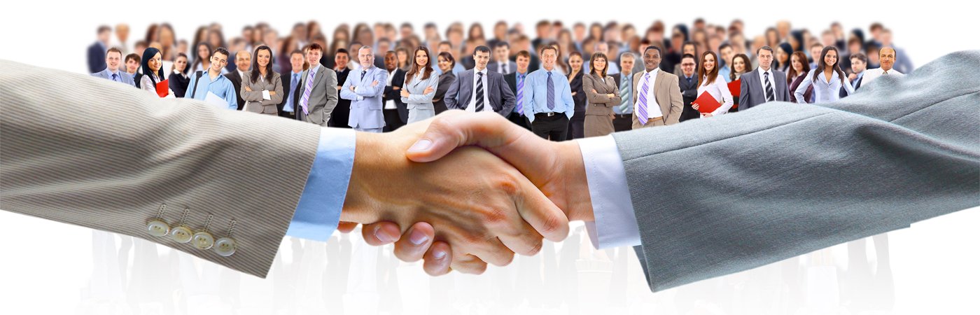 Человек в деловом костюме жмет руку другому человеку в толпе.