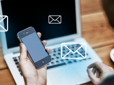 Электроника: человек с мобильным телефоном и ноутбуком, компьютер на заднем плане.