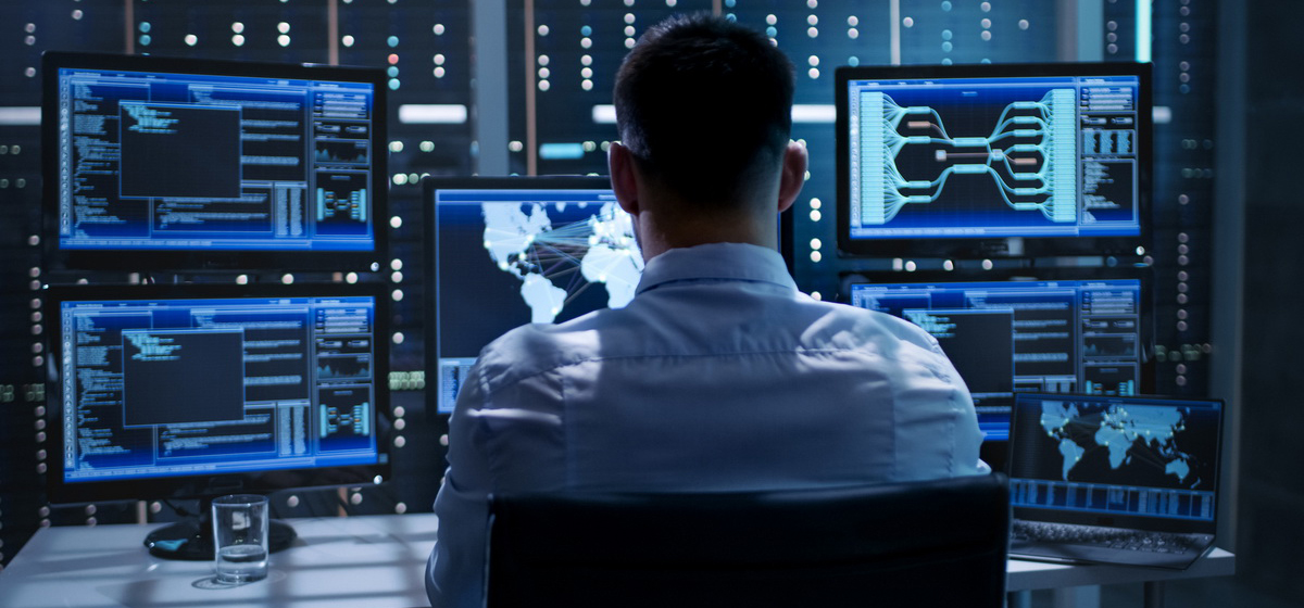 Взрослый мужчина смотрит на компьютерный монитор и ноутбук, электроника.