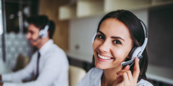 Человек счастливо улыбается в наушниках на фоне электроники.