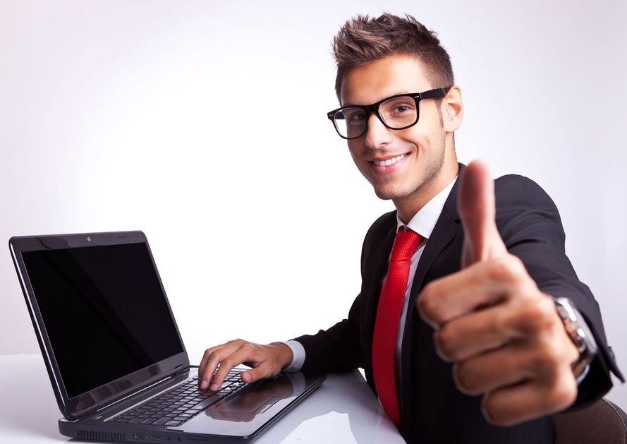 Мужчина с головой, лицом, пальцем на галстуке, работающий на ноутбуке.