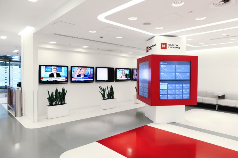 Монитор на столе с растением, электроника и компьютерное оборудование в помещении.