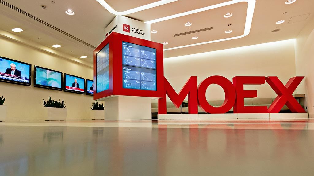 Компьютерное железо, мониторы, здание торгового центра, человек и растения на столе.