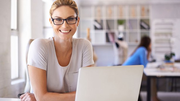 Ноутбук счастливый исполнитель с аксессуарами и очками на лице рабочего.