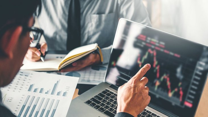 Мужчина работает за ноутбуком, на экране график. Компьютер, электроника.