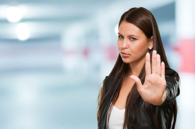 Человек в пальто смотрит на камеру, держа руку у лица. Фотопортрет.