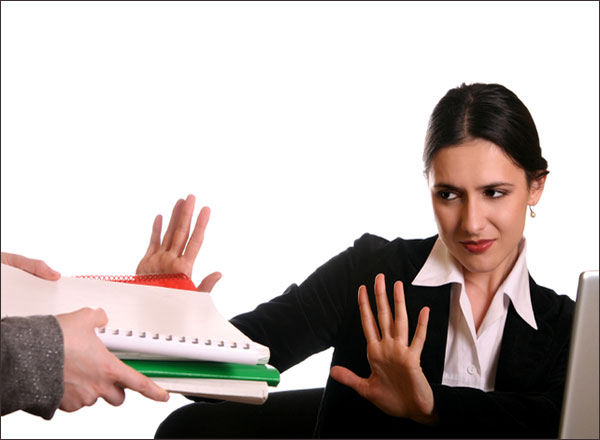 Женщина читает на ноутбуке, держа палец на клавише, сосредоточенно смотря в монитор.