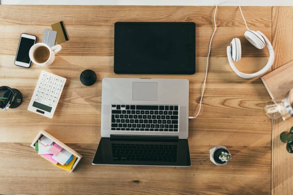 Компьютер на столе с ноутбуком, мобильным телефоном и электроникой.