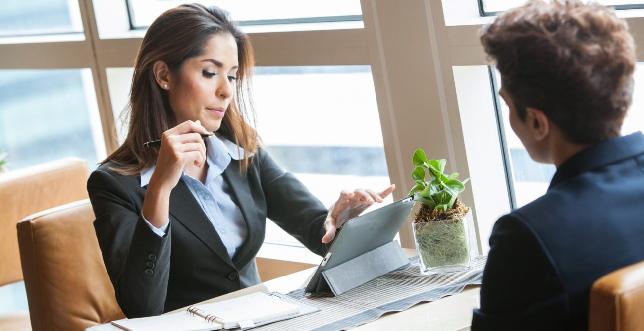 Рабочая женщина в костюме проводит интервью у растения, выражая важность беседы.