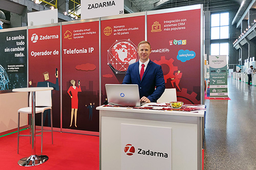 Мебель: стол, компьютер, лэптоп, аудитория, доска. Человек за письменным столом.