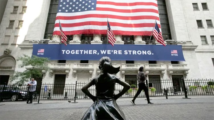 Женщина на городской улице с автомобилем и американским флагом.