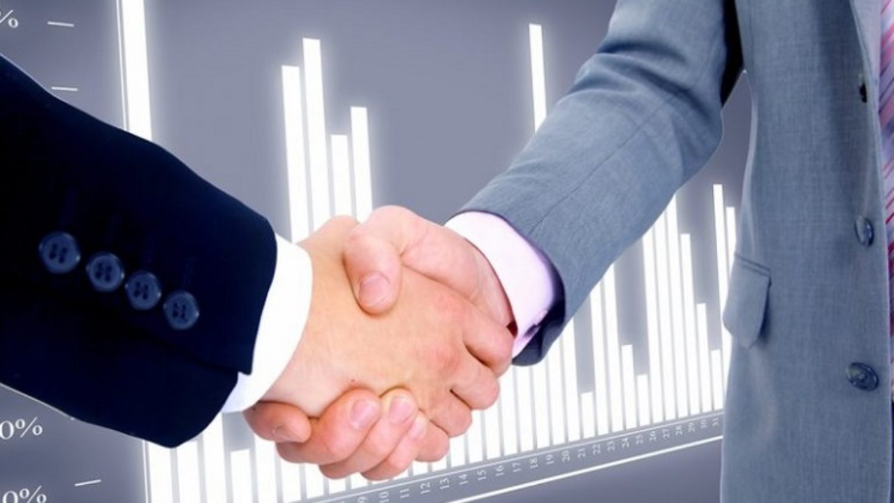 Человек в пальто имеет рукопожатие, показывая руку во время встречи.