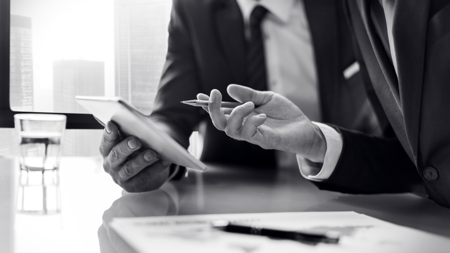 Человек в формальном костюме, показывающий палец руки в одежде на фоне.