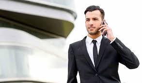 Фотография в телефоне: мужчина в черном пиджаке с галстуком и формальной одеждой.