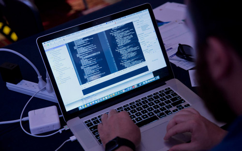 Человек использует ноутбук, компьютерный монитор, клавиатуру. Электроника и компьютерное оборудование.