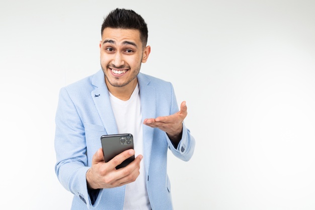 Фото счастливого мужчины смеющегося в телефоне, акцент на лице и голове.