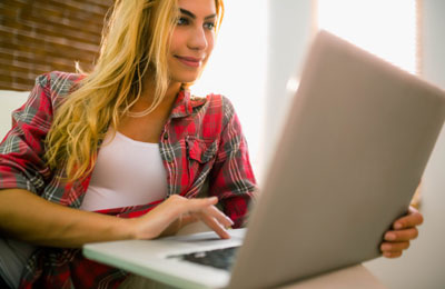 Ноутбук на фоне персоны с блондинистыми волосами в компьютерной тематике.