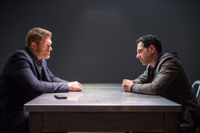 Респектабельный мужчина на интервью за столом, ведущий беседу.