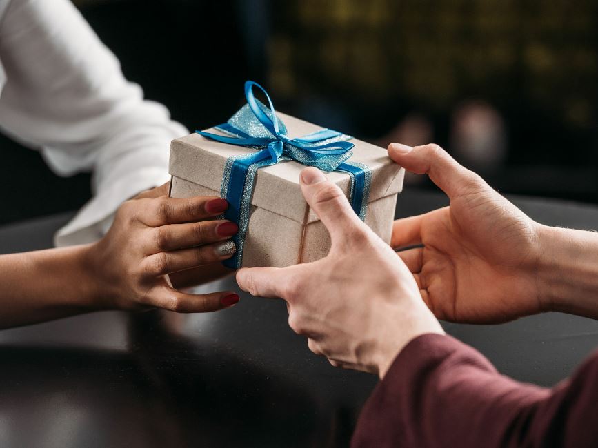 Человек открывает подарок с аксессуарами и кошельком: изображение аксессуаров.