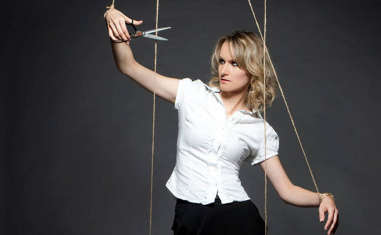 Ножницы в руках блондинки подстригающей волосы.