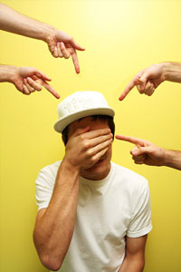 Фотография портрета человека с рукой на лице, в шляпе и футболке.