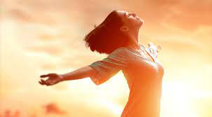 Человек на природе под солнечным светом, танцующий с бутылкой кетчупа в руке.