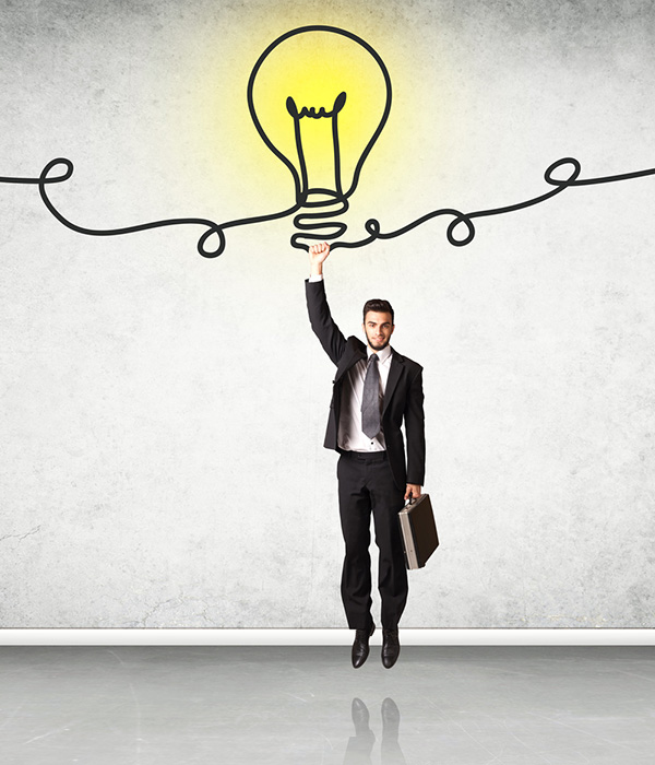 Мужчина в формальном костюме и пиджаке, стоящий под ярким светом.