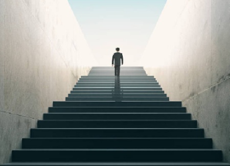 Архитектура здания с человеком стоящим на лестнице в пальто.