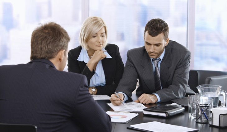 Женщина и мужчина взрослые общаются за столом с ручкой и галстуком.