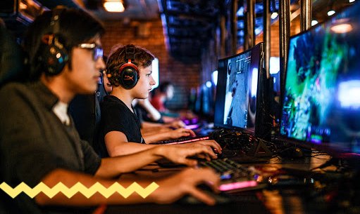 Человек играет на видеоиграх на мониторе с наушниками.