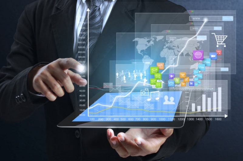 Взрослый мужчина с планшетом, работает над CAD-схемой компьютера и электроники.