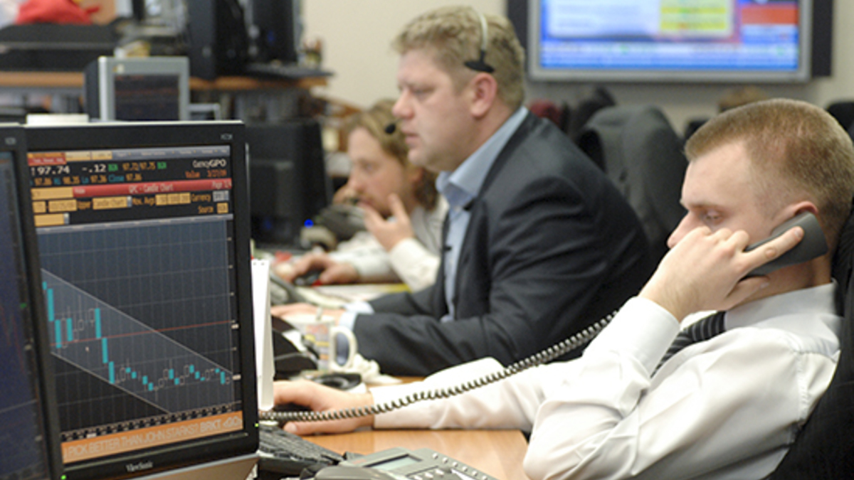 Электроника: человек в костюме за столом с монитором и компьютерной аппаратурой.