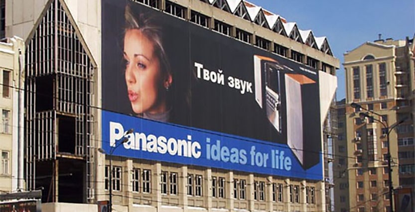 Реклама на здании: женщина смотрит на билборд, архитектура и лицо в фокусе.