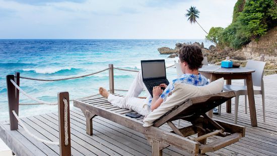 Мужчина на отдыхе у воды с ноутбуком на стуле - seo-оптимизированный текст.