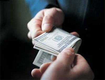 Деньги - стопка купюр различного номинала на деревянном столе.