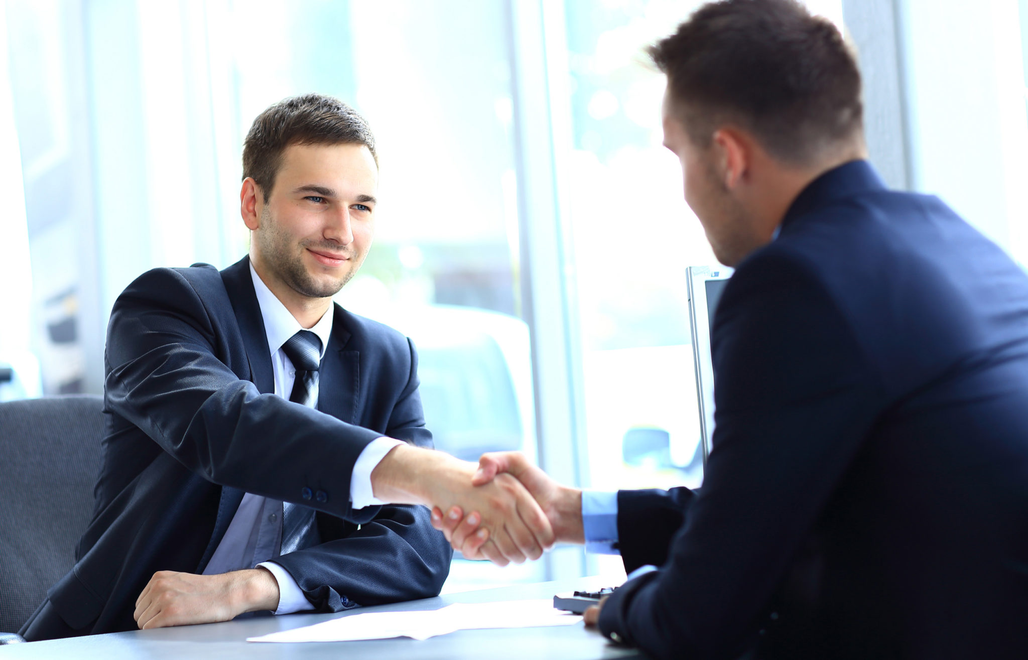 Взрослый мужчина в костюме, участвующий в беседе, сосредоточенно смотрит.