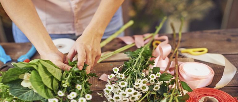 Человек использует острое лезвие ножа на деревянной разделочной доске для приготовления пищи.