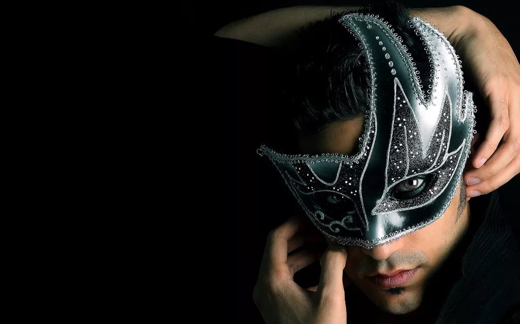 Человек в маске в толпе, портретное фото с головы. (Person wearing a mask in a crowd, headshot portrait.)