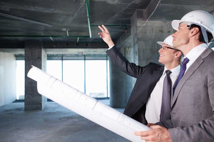 Мужчина-рабочий в защитной каске и очках с галстуком.