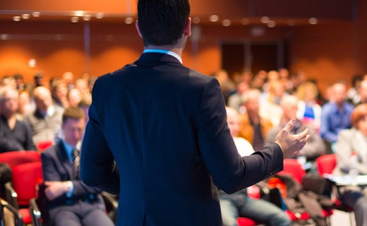 Взрослый мужчина в толпе на семинаре в помещении.