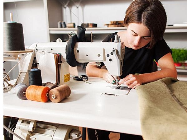 Взрослая женщина шьет на машинке: ключевые слова - взрослая, женщина, шитье, машина.