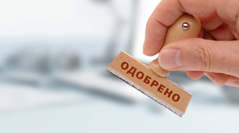 Человек пишет текст на бумаге, на его руке палец.